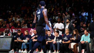 Fans wearing 'Fight Antisemitism' shirts sit courtside at Nets game