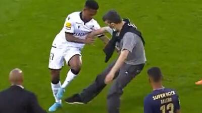 Fan kicks out at two players in Vitoria-Porto match after walking onto pitch wearing backpack