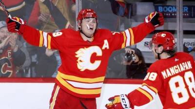 Flames clinch top spot in Pacific Division after catching fire late in win over Stars