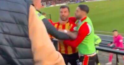 Richard Foster held back by Partick Thistle teammates during furious fan exchange