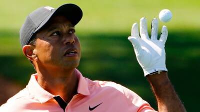 Tiger Woods warms-up at Augusta four days out from the Masters, saying he will make a 'game-time decision' on whether to play