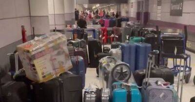 ‘Absolute pandemonium’: 'Abandoned' suitcases line Manchester Airport baggage hall as passengers told to go home without luggage