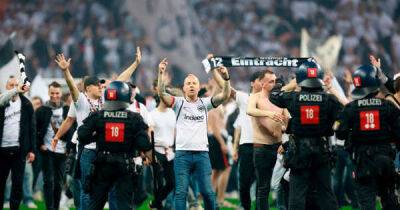Riot police push Eintracht Frankfurt fans back after pitch invasion with two West Ham supporters arrested