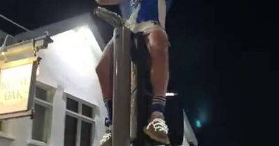 Bristol Rovers star climbs traffic lights and pours beer on head in wild promotion party