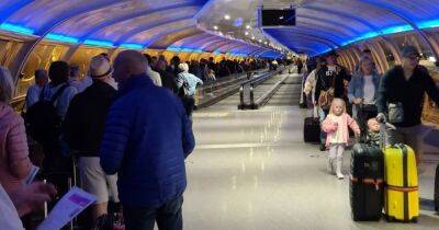 'Absolute shambles': Passengers face travel chaos at Manchester Airport as HUGE queue snakes along walkway and TUI website down
