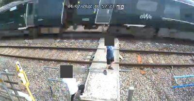 Warning to parents after kids dance on rail tracks as train roars past in alarming footage - manchestereveningnews.co.uk - Britain
