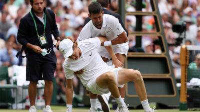 Wimbledon 2022: Novak Djokovic climbs over net to help Jannik Sinner after hard fall