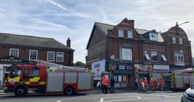 Crews rush to blaze after shop's sign catches fire