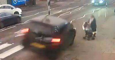 Shocking moment mum pushing pram on pavement narrowly misses being hit cay car