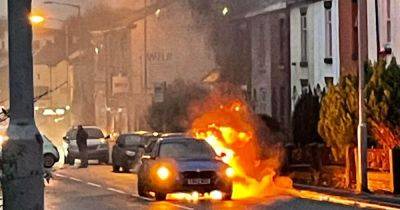 Dramatic photo shows car burst into flames on main road