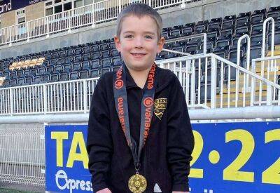 Former Maidstone United manager Hakan Hayrettin gives his National South championship medal to six-year-old fan Joshua Wright