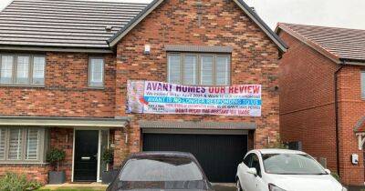 Man hangs huge banner outside £500,000 new build home in furious two-year row with developer - manchestereveningnews.co.uk