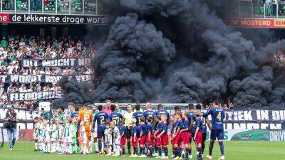 Ajax match abandoned after smoke bombs thrown on pitch