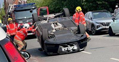Emergency services swarm street as two people cut from Audi that was flipped over onto roof in crash
