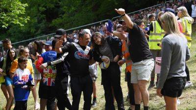 Canadian woman wins extreme UK cheese rolling race after getting knocked unconscious