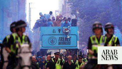Man City celebrate winning treble of major trophies with open-top bus parade in rain