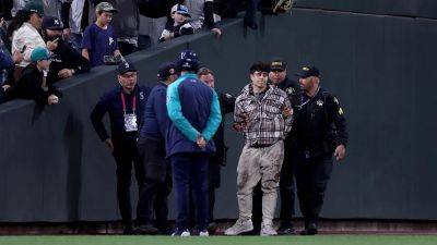 Fan at Mariners-Yankees game falls out of stands while attempting to help security stop man who ran onto field