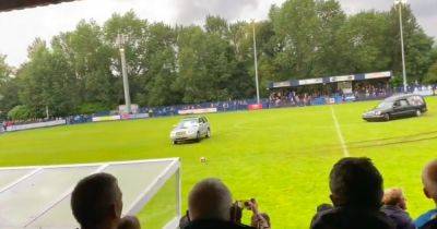 Non-league friendly abandoned as HEARSE drives onto the pitch before masked men flee in car