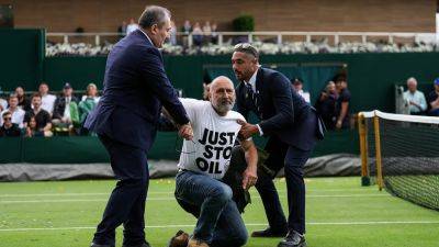Wimbledon protesters arrested after delaying play with climate change demonstration during men’s singles match