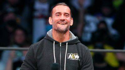 AEW star CM Punk poses with 'trans rights are human rights' sign at All In event