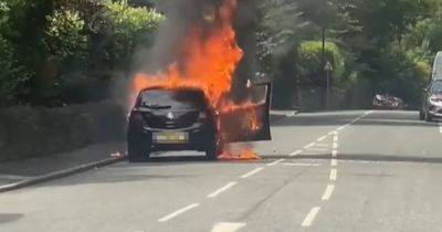 Man rushed to hospital after car bursts into flames on street