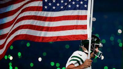 Jets' Aaron Rodgers carries American flag onto field in electric moment before injury