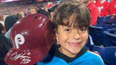 Young Phillies fan given helmet after Harper flips on ump - ESPN