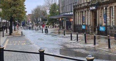 Town centre street flooded as pavement and shopping centre entrance taped off