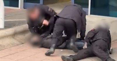 Police at Manchester Airport filmed 'kicking and punching' arrested man as he is pinned to the ground