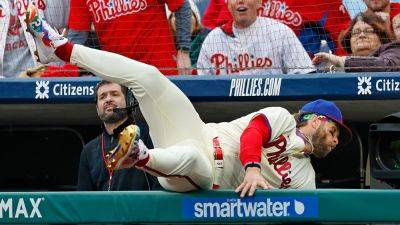 Phillies' Bryce Harper flips upside down trying to catch ball in dugout