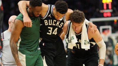 Bucks' Giannis Antetokounmpo helped off court with calf injury - ESPN