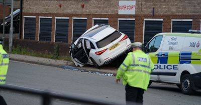 Dramatic photos show wrecked Mercedes mounted on wall as police shut main road
