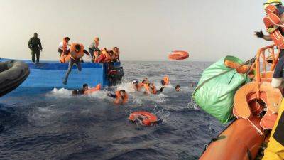 Migrants jump into sea as armed bandits climb onboard their boat during rescue mission