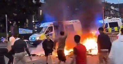 Riot police 'under attack' by huge crowd as mass disorder erupts on Leeds street with double decker bus and police car set alight