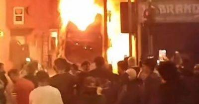 Double decker bus set alight as huge riot and scenes of violence continue in Leeds with hundreds filling streets