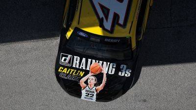 Caitlin Clark reacts to her image on hood of NASCAR's Josh Berry's vehicle