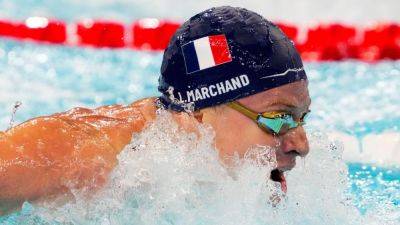 Léon Marchand sets two Olympic records; gold medal haul at 3 - ESPN