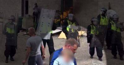 Yob dad caught clutching his child in the middle of a riot - manchestereveningnews.co.uk