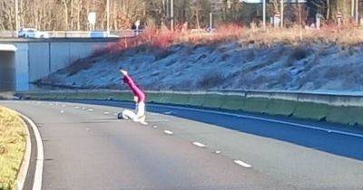 Woman seen doing YOGA in middle of A555 near Manchester Airport shut due to severe flooding