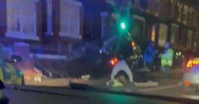 Car overturns after smashing into house with emergency services at scene - manchestereveningnews.co.uk