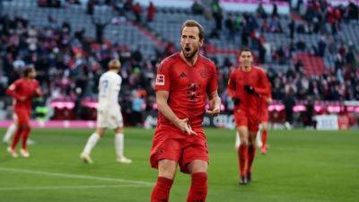 Record-breaking Kane nets twice as leaders Bayern earn 4-3 win over Kiel